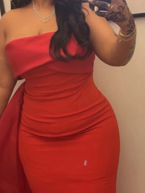 Röd axelbandslös långklänning - Nypris 5200:- Snygg röd axelbandslös långklänning med figurnära passform och elegant fall. Klänningen har en  stilren look med ett elegant släp och är perfekt för speciella tillfällen där man vill se lyxig ut. Tillverkad i ett slätt tyg som ger en bomb känsla.