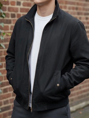 Svart bomberjacka från Canson strl S - Stilren svart bomberjacka från Canson med dragkedja framtill, ribbade muddar och två fickor med tryckknappar. Klassisk krage och diskret design som passar till det mesta. Tillverkad i ett mjukt tyg som känns bekvämt.                                          2