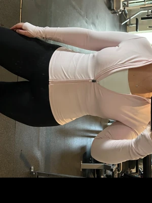 Ljusrosa träningsjacka - Säljer en ljusrosa träningsjacka med hel dragkedja framtill och hög krage. Jackan har långa ärmar och är tillverkad i ett stretchigt, mjukt material som passar perfekt till gymmet eller löprundan. Den första bilden visar den riktiga färgen🩷