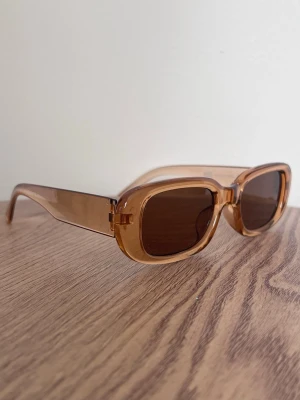 Bruna Y2K it-girl solglasögon – chunky 00s - Trendiga bruna solglasögon i chunky systemet-modell. 00s/Y2K it-girl känsla. Så snygga till low waist jeans, tanktop och slick bun!!! Aldrig använda. 