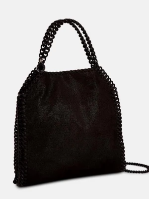 Svart Stella McCartney Falabella väska - Säljer en hel svart Falabella handväska från Stella McCartney med kedjehandtag och axelrem. Väskan har en mjuk, glansig yta i veganskt material och dekorativa kedjor längs kanterna. Perfekt för dig som gillar en edgy och trendig look. Nypris 8100kr