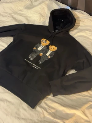 Ralph lauren hoodie - Knappt använd hoodie från Ralph lauren med deras polo bear tryck. En av de dyrare modellerna då insidan är i ett skönare fleece material för att hålla värmen! Kan gå lägre vid snabb affär🫱🏻‍🫲🏼🐻