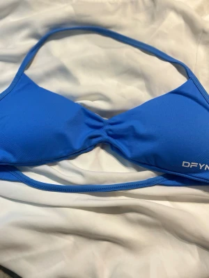 Impact strappy bra DFYNE - I princip helt ny sport-BH, Äkta DFYNE i färgen electric blue. Storlek S. Denna är använd någon enstaka gång men köptes i januari. Kuporna är avtagbara. Kvitto kan visas om det behövs. Denna säljes på grund av att den inte passade mig!