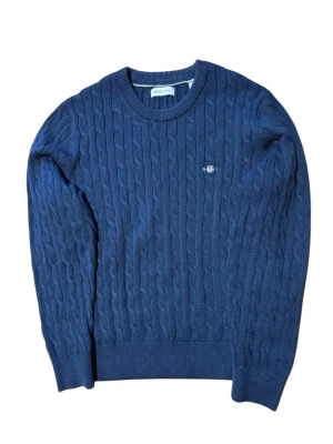 Kabelstickad Gant Tröja - Kabelstickad mörkblå tröja från Gant. Superfin och ger dig en väldigt snygg look. Inga defekter/skador alls så vid frågor och funderingar så är de bara att höra av