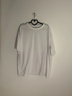 Vit relaxed fit t-shirt från H&M - En enkel och clean vit t-shirt från H&M med relaxed fit. Gjord i COOLMAX-material som känns lätt och bekvämt. Klassisk rund hals och korta ärmar, perfekt för dig som gillar en loose och avslappnad stil.