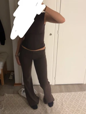 Bruna ribbade leggings med utsvängda ben - Snygga bruna leggings med ribbad struktur och utsvängda ben. Hög midja och stretchigt material som sitter bekvämt. Perfekta för en trendig och avslappnad look. Igentligen högmidjade men funkar bra att vika ner! 