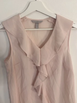 Ljusrosa blus med volang från H&M - Rosa topp/blus från hm i strl 36, perfekt inför sommaren
