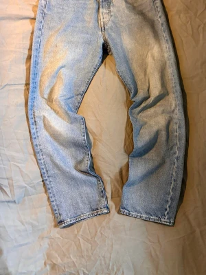 Levi's Premium ljusblå raka jeans - Säljer ett par klassiska ljusblå Levi's Premium jeans med rak passform och fem fickor. Jeansen har kopparfärgade nitar och är tillverkade i slitstark denim. Perfekta för en avslappnad och trendig look.
