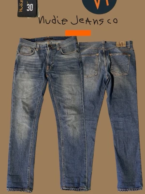Ljusblå Nudie Jeans  - Säljer ett par klassiska blå jeans från Nudie Jeans. Jeansen är en slim fit-modell med fem fickor, snygga slitningar och kontrastsömmar. Tillverkade i mjukt denimtyg som ger en avslappnad men stilren look.