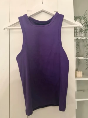Lila ribbad linnetopp från BikBok - Snygg lila ribbad linnetopp från BikBok. Modellen är ärmlös med hög halsringning och croppad passform, perfekt till jeans eller kjol. Materialet är mjukt och stretchigt för en bekväm känsla.
