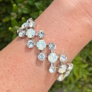 Armband kristaller silverpläterad mässing  - Armband med blandade kristaller i tre rader, egen design. Silverpläterad mässing. Ss 29 6mm, ss39 8mm. Färg, Clear Crystal och White Opal. Längd 21cm inkl lås och förlängningskedja. Sista bilderna visar andra färger på armband. Jag skickar endast spårbart med post nord, samfraktar. Besök gärna mina övriga annonser.  Till mina smycken använder jag kristaller från Preciosa, Aurora och Swarowski.