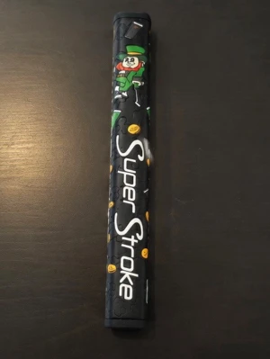 SuperStroke Pistol 1.0 puttergrepp - Säljer ett svart SuperStroke Pistol 1.0 puttergrepp med gröna svart och vit på sig. Greppet har texten 'SuperStroke' i vitt och är designat för golfputters. Materialet är greppvänligt gummi.