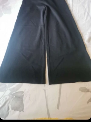 Svarta vida leggings - Säljer ett par svarta leggings med riktigt vida ben och hög midja. De är stretchiga och mjuka, perfekta för en avslappnad och trendig look. Materialet känns som en blandning av bomull och elastan. Inga synliga detaljer eller fickor. Zara