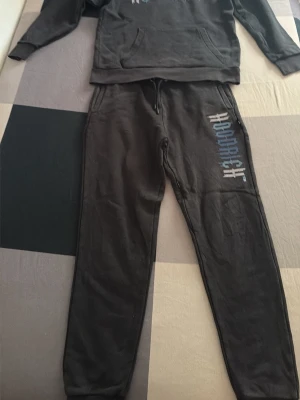 Svart Hoodrich sett - Säljer en svart  Hoodrich sett med stor tryck på framsidan. Hoodien har en klassisk huva och är gjord i mjukt material som passar perfekt för chill dagar. Snygg och enkel design med ribbade muddar och avslappnad passform. (Ifall man vill köpa något enskilt så kan de kosta mer än halva)