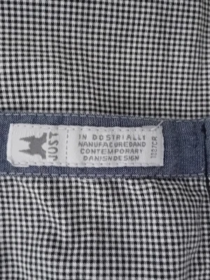 Svartvit rutig skjorta från Just - Snygg svartvit rutig skjorta från Just med klassiskt småmönstrat rutmönster. Skjortan har en broderad logga i grått och rött på bröstet och är tillverkad i ett mjukt, vävt tyg. Perfekt för dig som gillar stilren och modern dansk design.