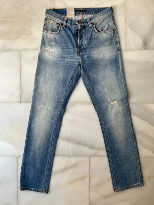 HELT NYA jeans med slitningar ifrån Nudie Jeans  - Säljer ett par NYA Nudie Jeans med riktigt snygga slitningar! ✌🏼 —————————————————————                                                                      📐| Storlek: 30-30                                                  👖| Märke: Nudie jeans                                         🔎| Skick: DOM ÄR NYA!                                               💵| Ny Pris: 1599kr                                                   ✍🏻| Skriv om du har några frågor