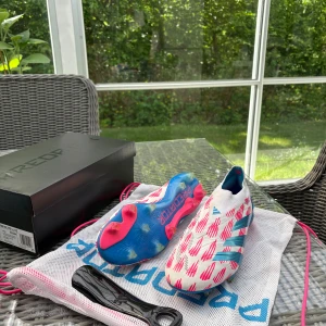Adidas Predator fotbollsskor vit/blå/rosa - Predator Elite LL FG storlek 43 ⅓  i ganska bra skick, de är lite smutsigare på bilden men inga håll eller skador på skrin! Ny pris ligger på 3200kr. Skriv vid frågor och intresse! 