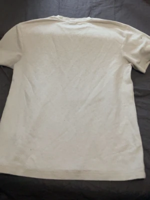 Vit basic t-shirt i bomull - En enkel och stilren vit t-shirt i mjuk bomull. Klassisk passform med korta ärmar och rund halsringning. Perfekt att matcha med jeans eller shorts för en clean look.