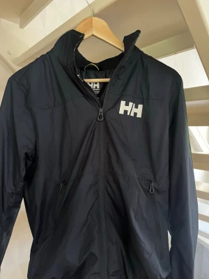 Mörkblå vindjacka från Helly Hansen - Snygg mörkblå vindjacka från Helly Hansen, storlek S. Skick 10/10. Pris kan diskuteras vid snabb affär. Skriv vid frågor eller fler bilder.