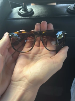 Bruna boyfriend solglasögon Ray-Ban - Säljer ett par klassiska Boyfriend solglasögon från Ray-Ban i brunmelerad färg. Snygg retrostil med bred båge och mörka glas. Perfekta för soliga dagar och ger en cool vibe till din outfit. Extremt lite använda som nya