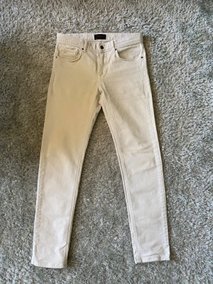 Vita J Lindeberg jeans strl 31/32 - Säljer ett par vita J Lindeberg slim fit jeans med klassisk femficksdesign och normal midja. Jeansen har smal passform hela vägen ner och är tillverkade i ett mjukt denimtyg med lite stretch för extra komfort. Perfekta för en clean och stilren look nu till sommaren. Lite tajta på mig och jag väger 75 kg, men längden ~180 cm är bra. Hör av er vid frågor och funderingar m!