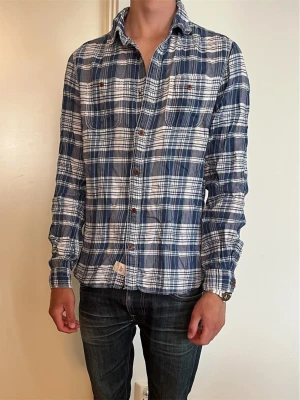 Woolrich Skjorta - Säljer nu denna sjukt snygga skjortan från Woolrich. Bra skick förutom att en knapp saknas, går att fixa. Modellen är 176, 60kg. Skriv vid funderingar!