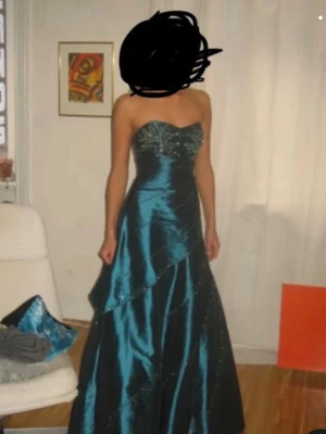 Turkos axelbandslös balklänning - Snygg turkos långklänning med glittriga detaljer och axelbandslös design. Klänningen har en figurnära överdel och utsvängd kjol med lager på lager-effekt. Perfekt för bal eller festliga tillfällen. Hoppas att den kommer i användning för någon annan student/ person som ska på bal eller event, eftersom den är jätte fin klänning. 