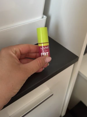 NYX Fat Oil läppglans rosa - NYX Fat Oil läppglans med en snygg rosa nyans och limegrönt lock. Glanset har en oljebaserad formula som ger glansiga och återfuktade läppar. Perfekt för dig som vill ha en trendig och fräsch look. Kommer i en smidig tub med skruvlock. På