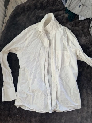 Vit skjorta från 157 med bröstficka - Klassisk vit skjorta från 157 i storlek S. Skjortan har lång ärm, bröstficka och knäppning framtill. 