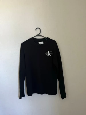 Stickad Calvin Klein tröja  - Svart stickad tröja från Calvin Klein i storlek 14 år, skulle säga att det är som en xs. Är i bra skick men lite nopprig. 