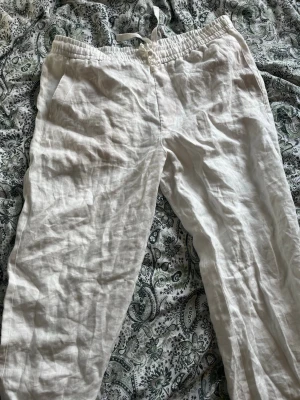 Vita linnebyxor zara - Säljer ett par vita linnebyxor med avslappnad passform och resår i midjan samt dragsko. Byxorna har fickor både fram och bak, perfekta för chill dagar. Tillverkade i svalt och luftigt linne som passar perfekt till sommaren.