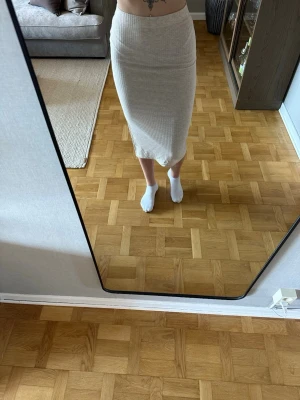 Beige ribbad midikjol med slits - Beige midikjol från Only med ribbad struktur och slits på sidan. Kjolen har en tight passform. Använd endast 2/3 gånger. Jag är 168cm