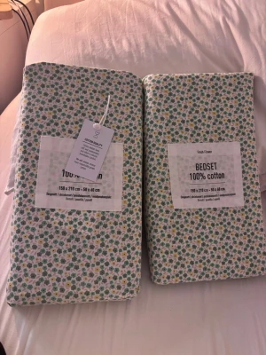 Blommigt och randigt bäddset i bomull - Säljer två påslakanset i 100% bomull. Mått: 150x210 cm och 50x60 cm. Perfekt för dig som vill ha ett fräscht och somrigt sovrum.