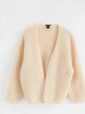 Beige kofta från Lindex  - Mysig beige kofta från H&M med öppen front och avslappnad passform. Tillverkad i ett fluffigt material som ger en soft och trendig look. Perfekt att slänga över en t-shirt eller topp för extra värme.
