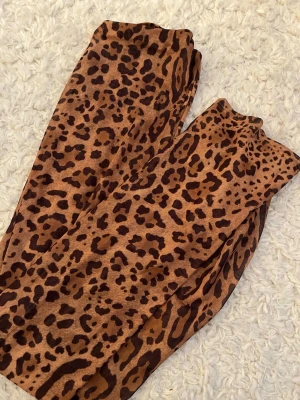 Leopardmönstrade leggings - Snygg lång kjol med leopardmönster i bruna och svarta toner. Stretchigt material som sitter tight och bekvämt. Perfekta för dig som vill sticka ut med en djurinspirerad look.