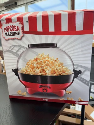 Röd popcornmaskin med glaskupa - Popcornmaskin från Gadgy i röd och svart design med rund glaskupa. Perfekt för hemmabio eller filmkvällar. Maskinen har ett retroinspirerat utseende och är enkel att använda med en knapp på framsidan. Poppar snabbt stora mängder popcorn.