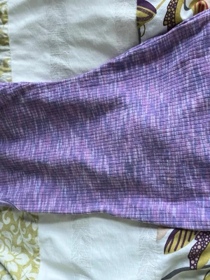 Lila ribbad klänning från H&M Divided - Säljer en lila ribbad klänning från H&M Divided i storlek XS. Klänningen har ett rutigt mönster i olika lila och rosa nyanser och är ärmlös med en kroppsnära passform. Perfekt för dig som gillar färg och mönster!