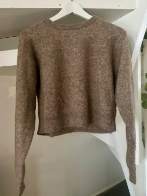 ZARA stickad tröja beige  - Mysig beige stickad tröja från Zara i lama/ull blandning med rund halsringning och långa ärmar. Tröjan har en något kortare passform och ribbade muddar vid ärmslut och nederkant. Perfekt för lager på lager och enkel att matcha till olika outfits.