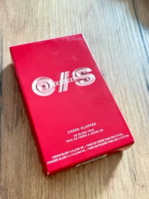 ONE/SIZE Cheek Clapper 3D Blush Trio - ONE/SIZE Cheek Clapper 3D Blush Trio i färgen Attention Seeker. Innehåller tre nyanser: Thirsty, Yes Sir och Kisses Please. Paletten har både krämrouge och puderrouge i en snygg rosa och röd förpackning. Perfekt för att skapa dimension och glow på kinderna. Det vita är Vaxblomning som är en ofarlig, grumlig vit dis som uppträder på ytan av färgade blyertsteckningar, vaxskulpturer, läder eller läppstift.