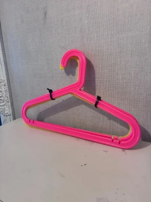 2st rosa och 2st gula galgar IKEA - Säljer ett set med plastgalgar i neonrosa och neongul. Galgarna har en klassisk trekantig form och är perfekta för att hänga upp kläder i garderoben. 2st gula och 2st rosa