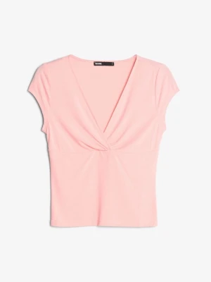 Ljusrosa omlottopp  - Supersöt ljusrosa topp från Bik Bok med omlottdesign och v-ringning. Toppen har korta ärmar och har ett mjukt bomullsmaterial. 