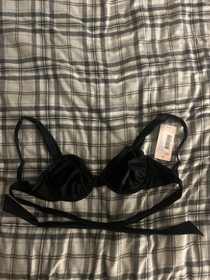 Svart bikiniöverdel med knyt - En väldigt fin bikini topp från Nelly som är helt ny, jag säljer den just för att den är i fel storlek för mig 💗 Den är i storlek 70D men skulle kunna passa som 70C! 💗