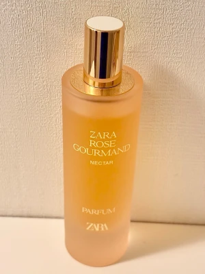 Zara Rose Gourmand Nectar 80 ml - Zara Rose Gourmand Nectar, 80 ml. En fruktigare och mer gourmand-version av Rose Gourmand. Rosen behåller sin karakteristiska blomster elegans medan päron tillför en saftig och delikat klarhet. Karamellen introducerar en krämig sötma som förstärker doftens sensualitet och lämnar ett varmt och beroendeframkallande spår. Knappt använd, vilket syns på bild. Kommer i originalförpackningen. 