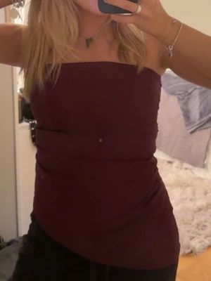 Asymmetrisk tubtopp - Snygg mörkröd tubtopp. Toppen har en tight passform och är perfekt att matcha med både jeans och kjol🥰