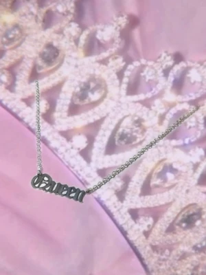 Silverfärgat Queen-halsband - Snyggt halsband i silverfärg med texten 'Queen' i coolt typsnitt. Kedjan är tunn och elegant, perfekt för att ge din look en extra touch av attityd. Passar dig som vill sticka ut och visa vem som bestämmer.