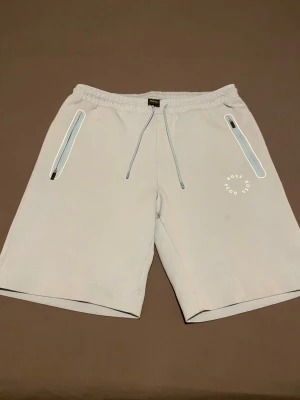 Nike blå träningsjacka med quiltad front - Mörkblå träningsjacka från Nike med quiltad frontpanel och halv dragkedja. Jackan har lång ärm, hög krage och en vit Nike-logga på ärmen. Perfekt för löpning eller träning utomhus när det är lite kyligare.