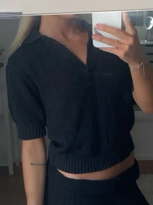 Svart stickad pikétröja - Snygg svart stickad pikétröja med korta ärmar och krage. Använd ett fåtal gånger💕