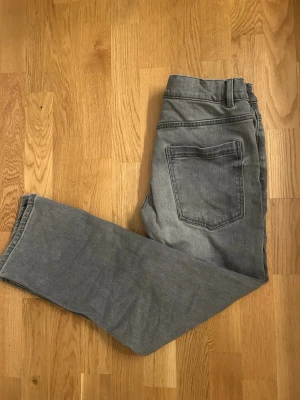 Grå jeansbyxor från Lindex  - Snygga grå jeansbyxor från Lindex i rak modell. Byxorna har klassisk femficksdesign. ordinarie pris 349kr. Perfekt för dig som gillar enkel och stilren look. Materialet är slitstarkt jeans. 