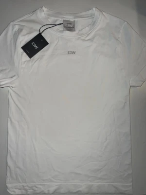 Vit tränings t-shirt från ICANIWILL - Tight träningströja från ICIW helt ny! Köptes precis för 450kr men var för liten och kunde inte lämna tillbaka. Den är kort och tight i modellen. Tyvärr för liten så kan inte visa en bild på men kommer tydligt upp bild om man söker på deras hemsida!!