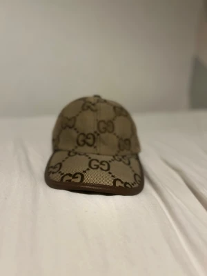 Beige GG-mönstrad keps - GG mönstrad keps som är guldig/brun. Knappt använd utanför hemmet.